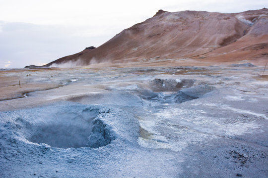 Boiling hot blue coloured mud puddle with Namafjall in the background, at Hverar ndor Hverir Geothermal Area, at Namaskard Pass in Iceland.