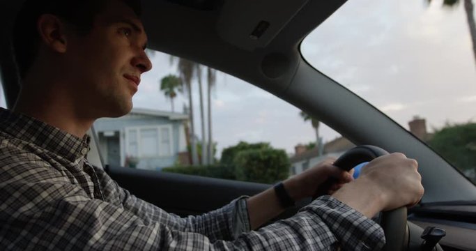 Young man driving car and watching reat view mirror - someone following