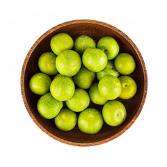 Overhead view of plums in a bowl on white background