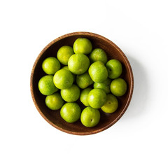 Overhead view of plums in a bowl on white background
