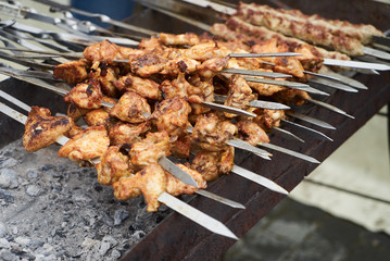 Roasted chicken wings kebab on skewers, close-up, outdoors. 