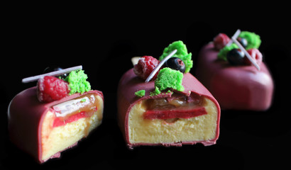 Sliced pink berries and pistachio gelato ice cream on stick with raspberries, black currants and green sponge