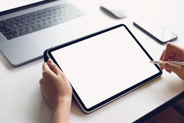 Woman using tablet screen blank and laptop on the table mock up to promote your products. Concept...