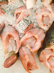 Fresh fish slices steak laid on ice in the store. Close-up concept of nutrition and health