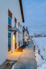 Pathway along homes and snowy ground in winter