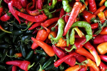 Mixed colour of chilli on a surface of a bucket, top view.