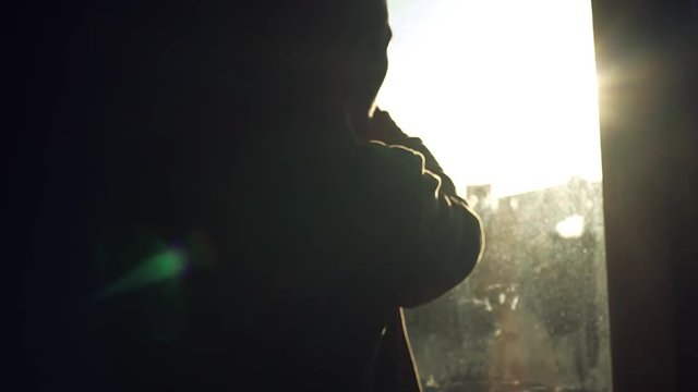 Shot of silhouette man open striped blinds on a window in dark dirty window jalousie installing apartment interior inside sunlight view closeup flat close up slow motion
