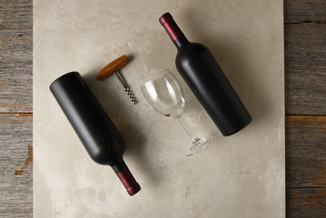 Two bottle of cabernet sauvignon wine on a gray tile surface on a rustic wood table
