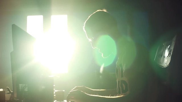 Silhouette young attractive man working eat use computer in the office communication sunlight computer designer internet sunset technology happy networking online slow motion