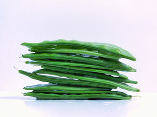 Stack of snowpeas on a white back drop