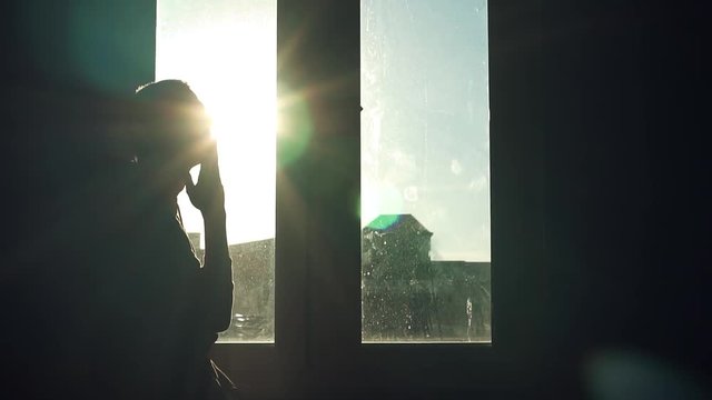 Shot back silhouette young man stand near window walk sad nervous thinking sunset sunlight suicide in room dark close up slow motion