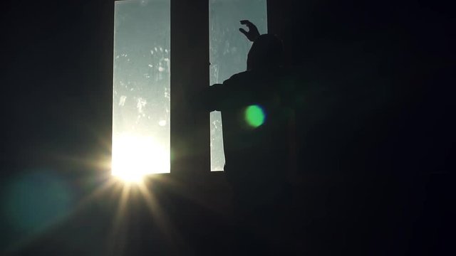 Nervous silhouette young man stand near window walk sad nervous thinking sunset sunlight tired angry suicide in room dark close up slow motion