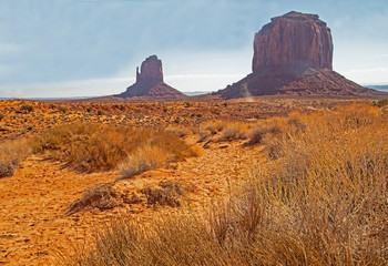 Monument Valley famous rock formations under a blue sky.