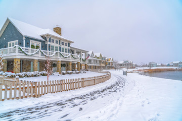 Snowy landscape with lakefront homes in Daybreak