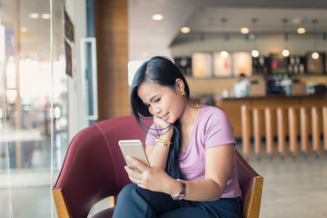 Young Asian beautiful woman using smart phone in coffee shop.