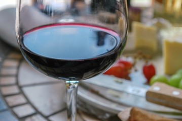 Close up of plate of good with out of focus red wine glass 