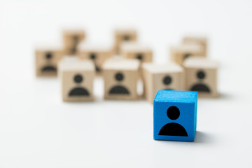 Leadership concept using blue people icon cube among many other cubes