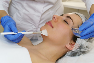 Cosmetologist applies moisturizing conductive gel before ultrasonic face cleaning procedure. Spa....