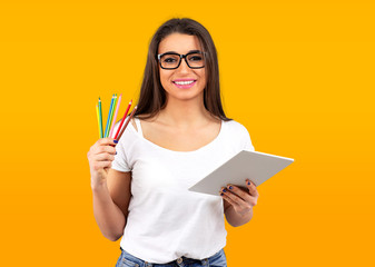 Happy graphic designer woman with colorful crayons and modern tablet computer