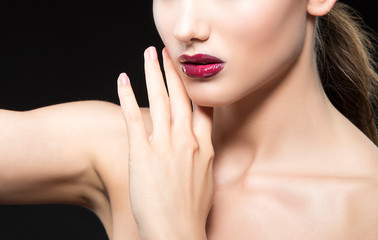 Fototapeta na wymiar Close-up red lips make-up of attractive young woman partial portrait, hands near face. Black background