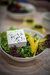 Salad bowl with soft tofu and black seed placed on top.