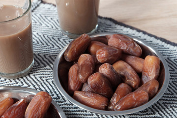 Bowl of dates fruit and glass of milk tea usually consumed when break fasting