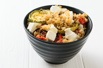 Salad of cheese, baked vegetables and boiled quinoa on a white table. Vegetarian dish.