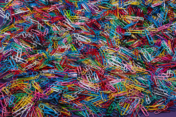 Macro closeup of scattered colorful plastic paperclips. Texture and backgrounds.