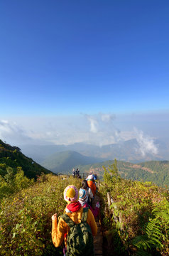 Travelers traveling in grassland, ecotourism in beautiful nature environment in trail on ridge of mountain view, hiker hiking on mountain, ecotourism trekker trekking over cloud and valley landscape