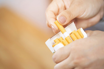 close up female  hand holding peel it off cigarette pack prepare smoking a cigarette. Packing line...
