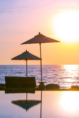 Umbrella and chair around swimming pool in resort hotel for leisure travel and vacation