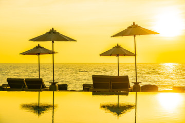 Umbrella and chair around swimming pool in resort hotel for leisure travel and vacation