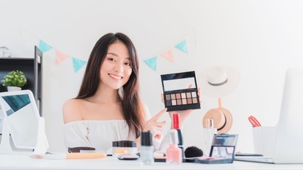 Beautiful asian woman blogger is showing how to make up and use cosmetics. In front of the camera...