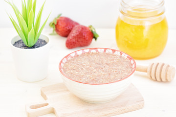 Delicious vegetarian breakfast. Useful porridge from flax seed strawberries and honey. Healthy food.