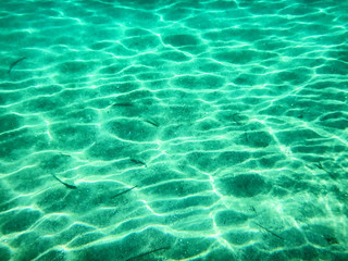 Sun glare on the seabed. Water texture for the background. Shooting under water