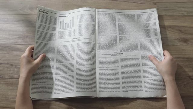 Hands open the the business Newspaper on wooden table in the office, Daily Newspaper mock-up concept