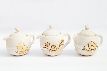 three white ceramic teapots stoneware with white background