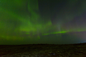 Green northern lights over the hills, aurora.