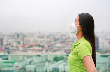 Young Asian woman wearing a protection mask against PM 2.5 air pollution in Bangkok city. Thailand....