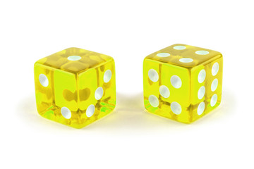 Two yellow glass game dice closeup isolated on white background. One and four with a shadow.