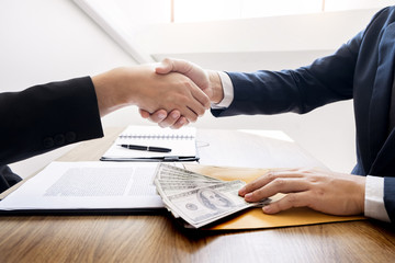 Dealing greeting and partnership meeting concept, businessmen handshaking after finishing up deal contract for both companies.