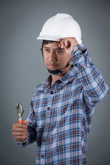 Builder holding hammer on grey background.