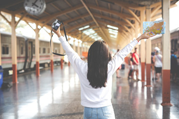 Happy women are taking pictures while traveling at the train station. Tourism concept