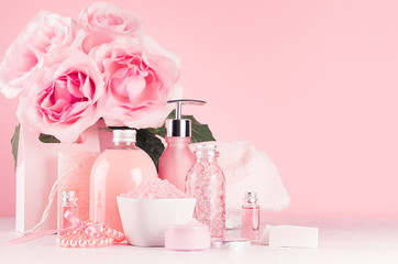 Elegant decor for romantic girlish dressing table - different bath and spa cosmetics, accessories, roses bouquet, round mirror in pastel pink color on white wood board.