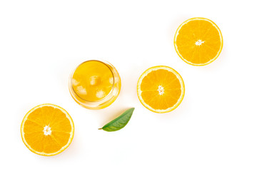 An overhead photo of a glass of fresh orange juice with orange halves and a green leaf on a white background with copy space