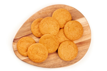 Gingersnaps on a wooden tray, shot from above on a white background