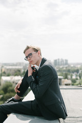 A man in a suit is talking on the phone. Advertising of men's clothes.