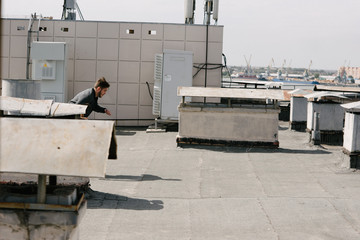 A man runs on the roof of the building. Advertising menswear.