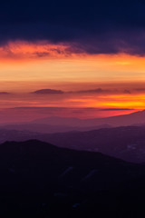 Beautifully colored sky at dusk, with mountains layers