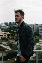 Fototapeta premium A man in a gray jumper with a zipper posing. Advertising of men's clothing.